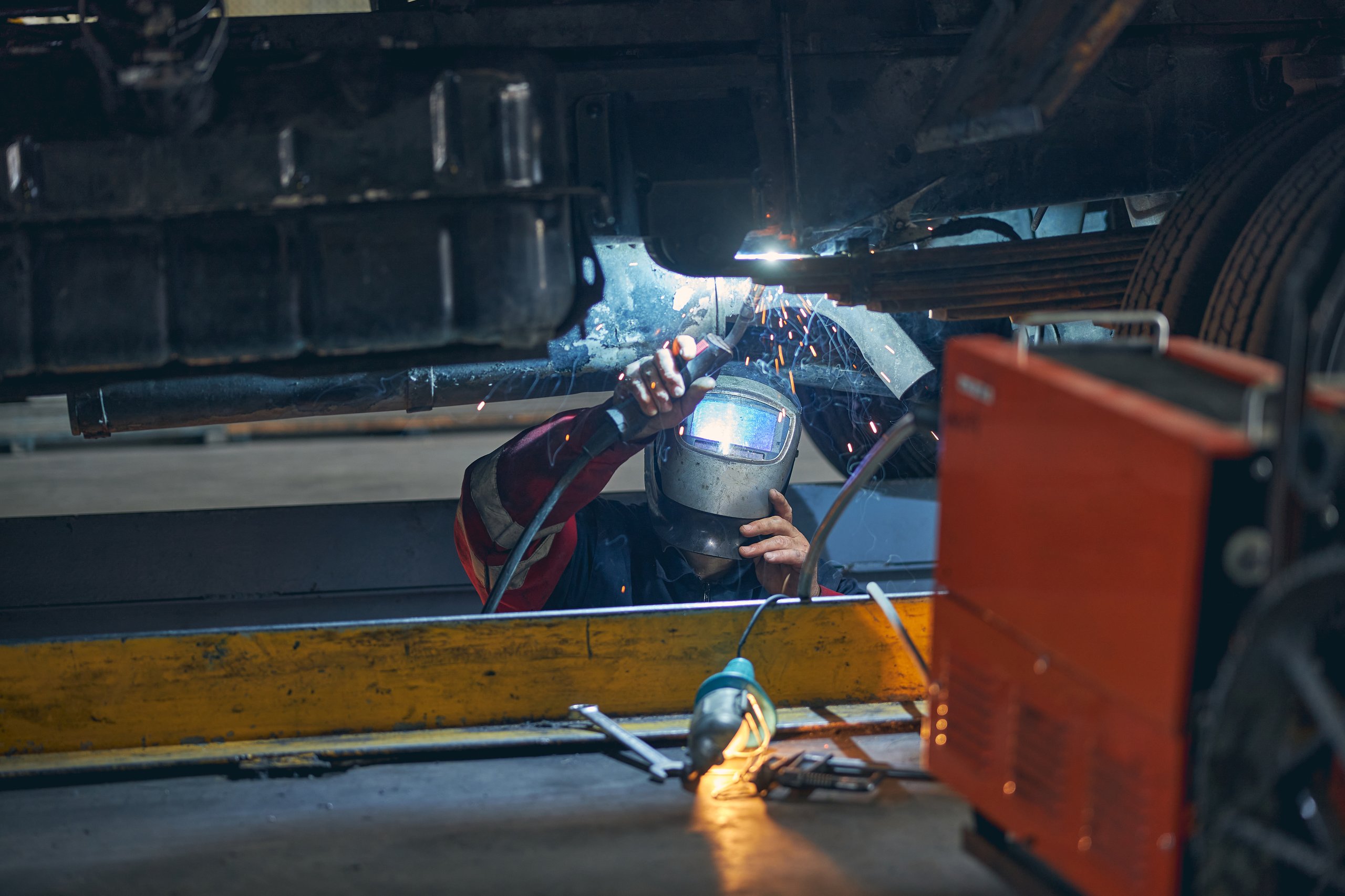 Professional welder working on vehicle frame
