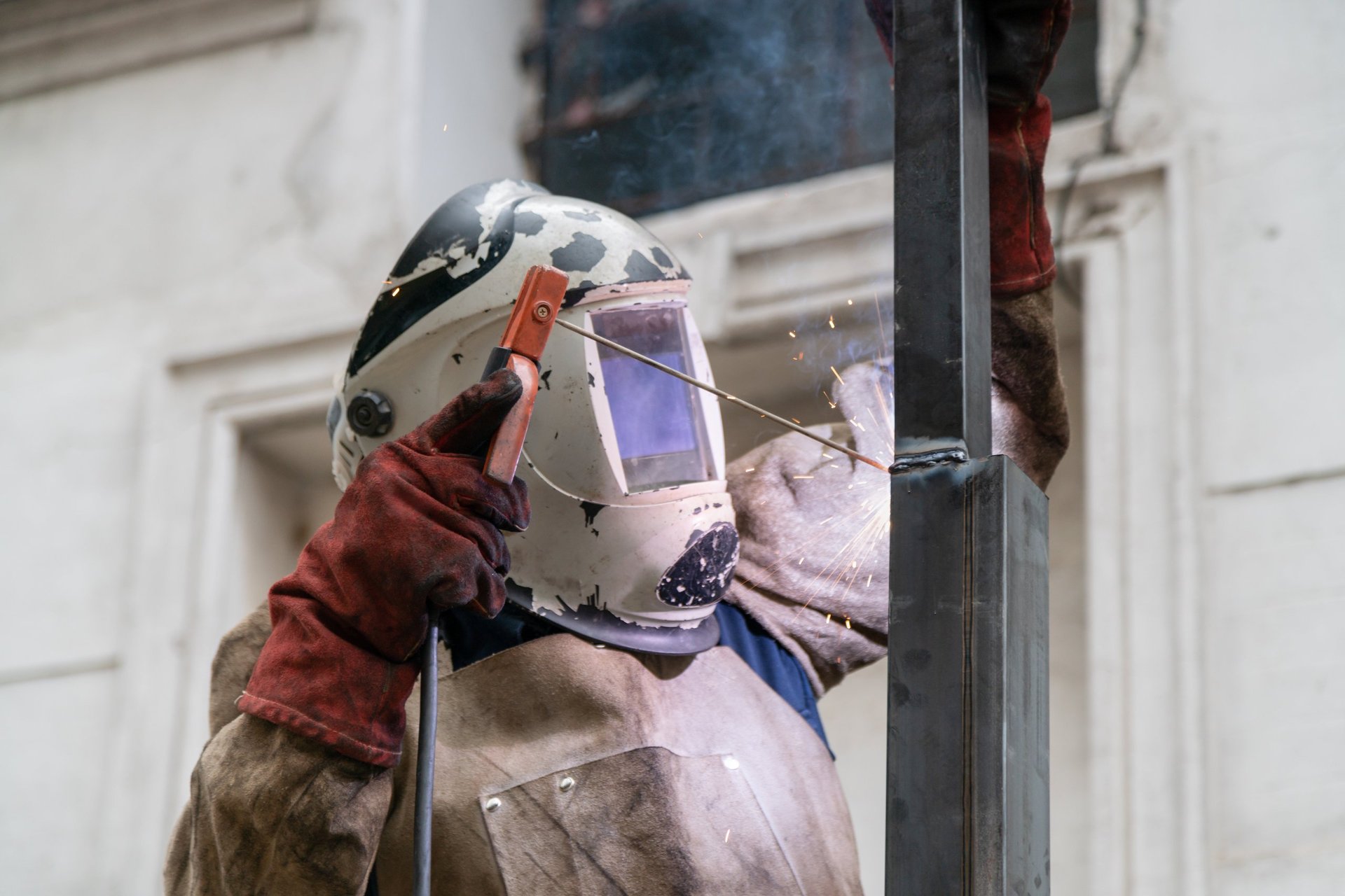 Professional welder wearing protective gear working on metal